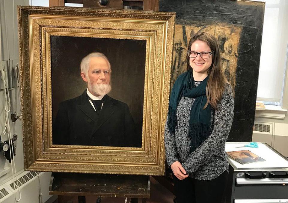 student Nicole Flam with the restored painting of Benjamin Franklin Chapman