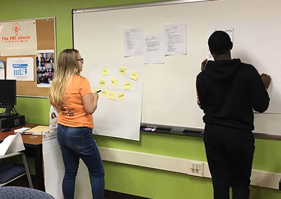 students writing on whiteboard